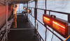 man working in a covered construction area with Heliosa construction heaters blanketing him in warmth